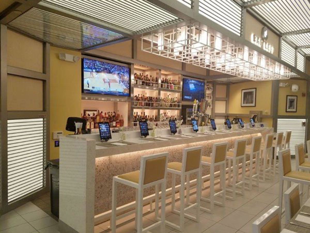 A bar with a lot of chairs and a television on the wall