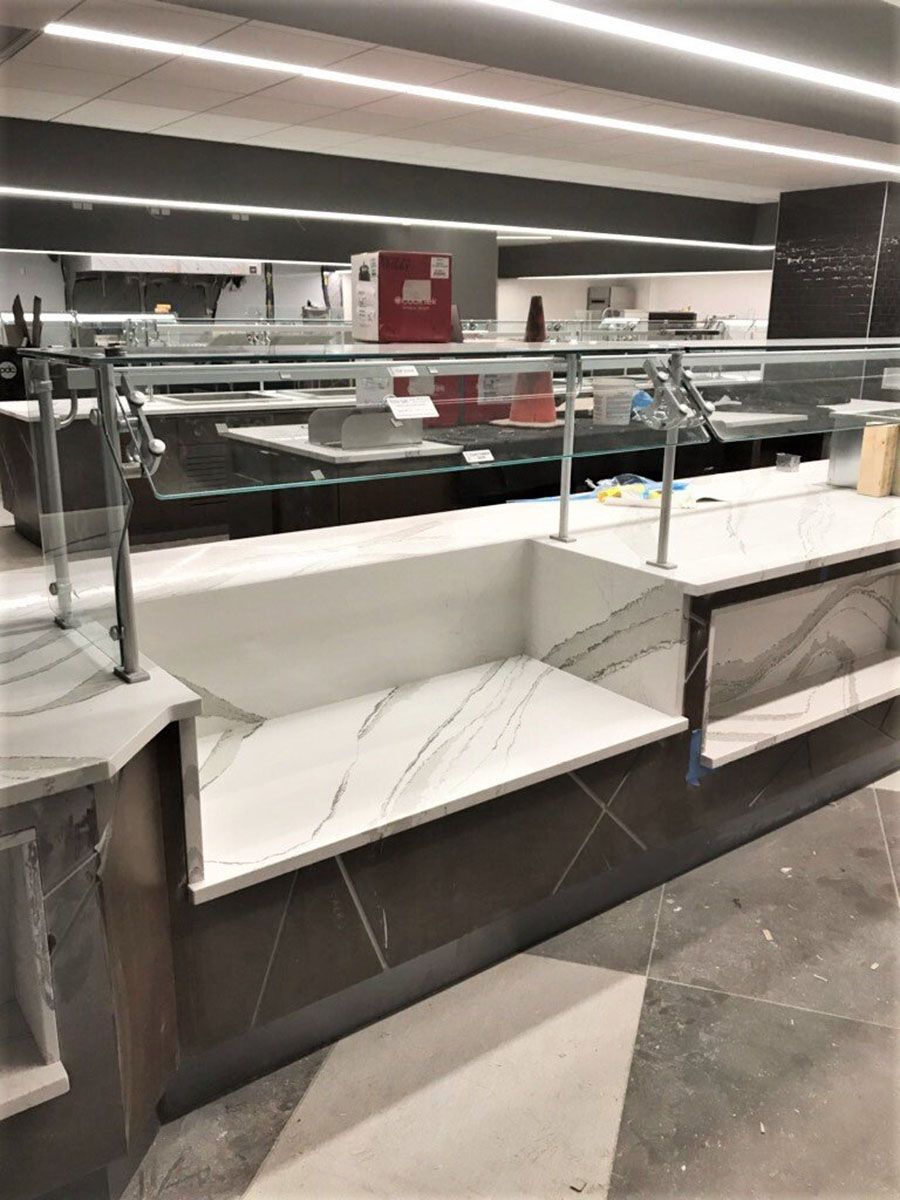 A buffet line in a restaurant with a marble countertop