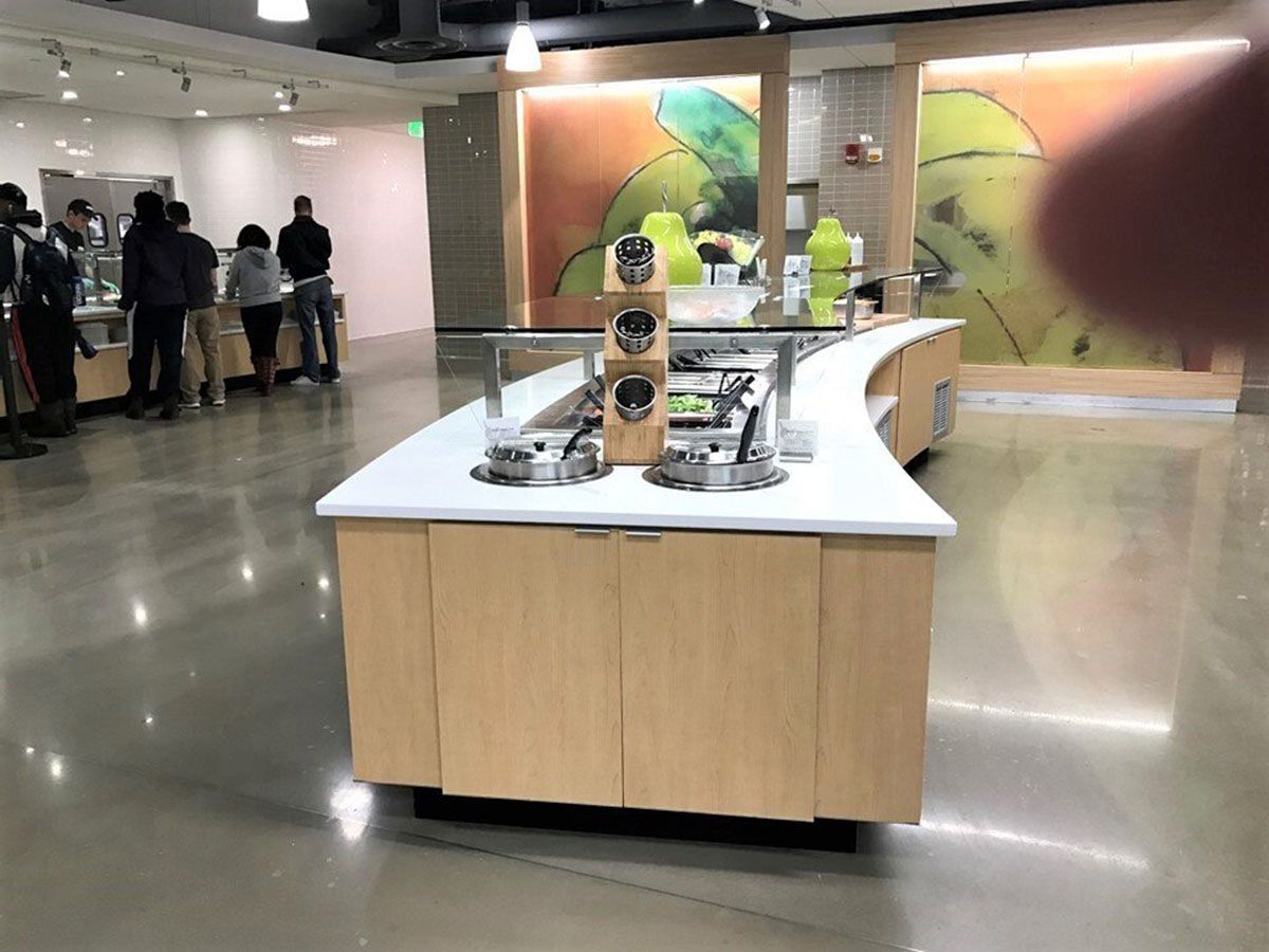 A group of people are standing in line at a buffet in a restaurant