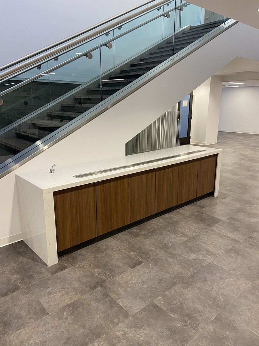 A staircase with a glass railing and a counter underneath it