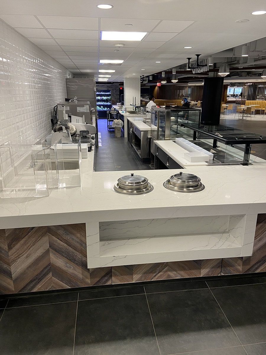A buffet line in a restaurant with white countertops