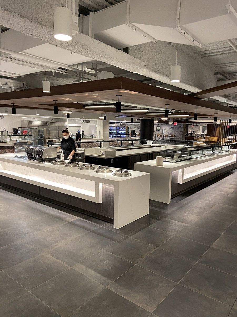 A man is standing at a counter in a restaurant