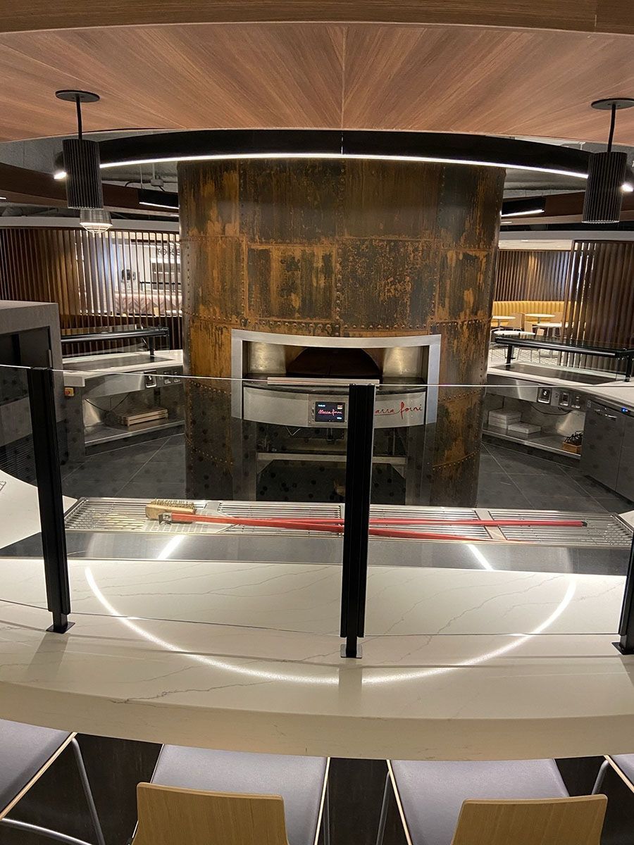 A large oven is in the middle of a restaurant