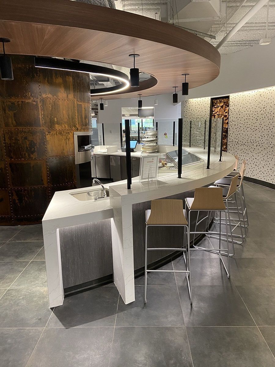 A large oven is in the middle of a restaurant with a circular countertop