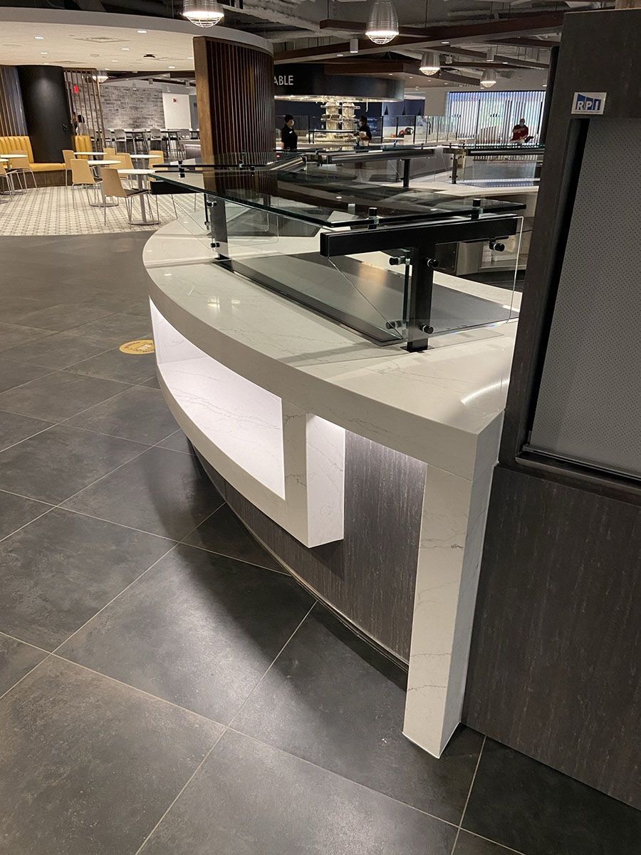 A restaurant with a curved counter in the middle of the room