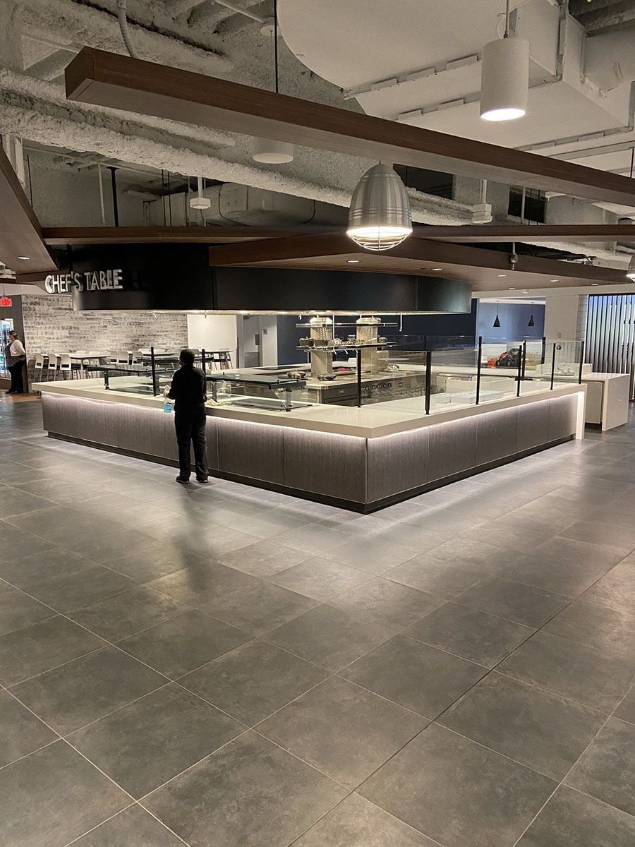 A man is standing in front of a buffet line in a restaurant