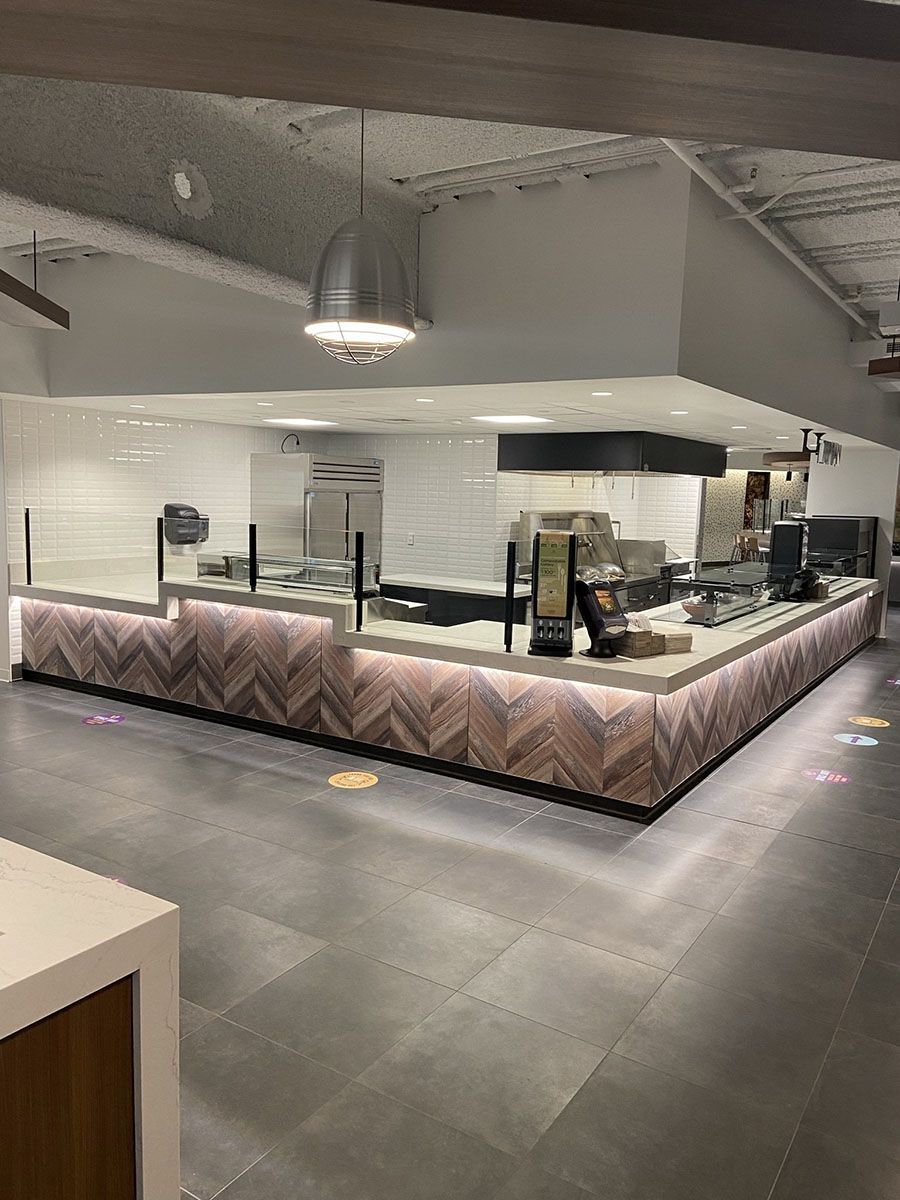 A restaurant with a long counter in the middle of the room