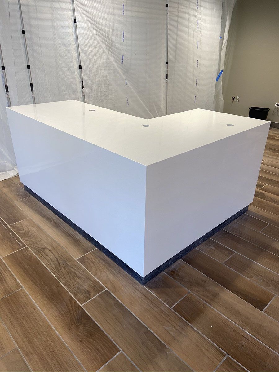 A white counter is sitting on a wooden floor in a room