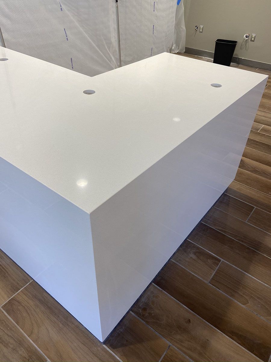 A white countertop is sitting on top of a wooden floor