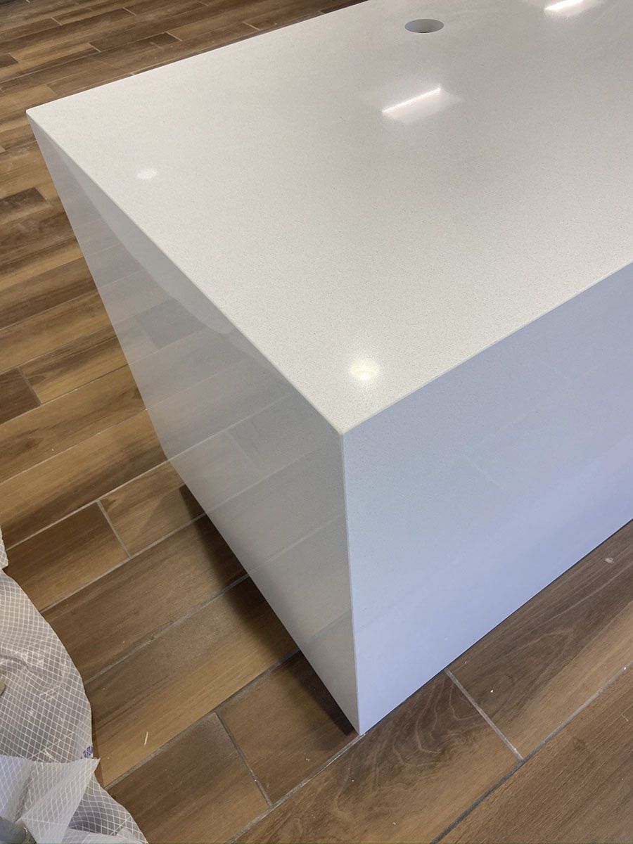 A white countertop is sitting on a wooden floor