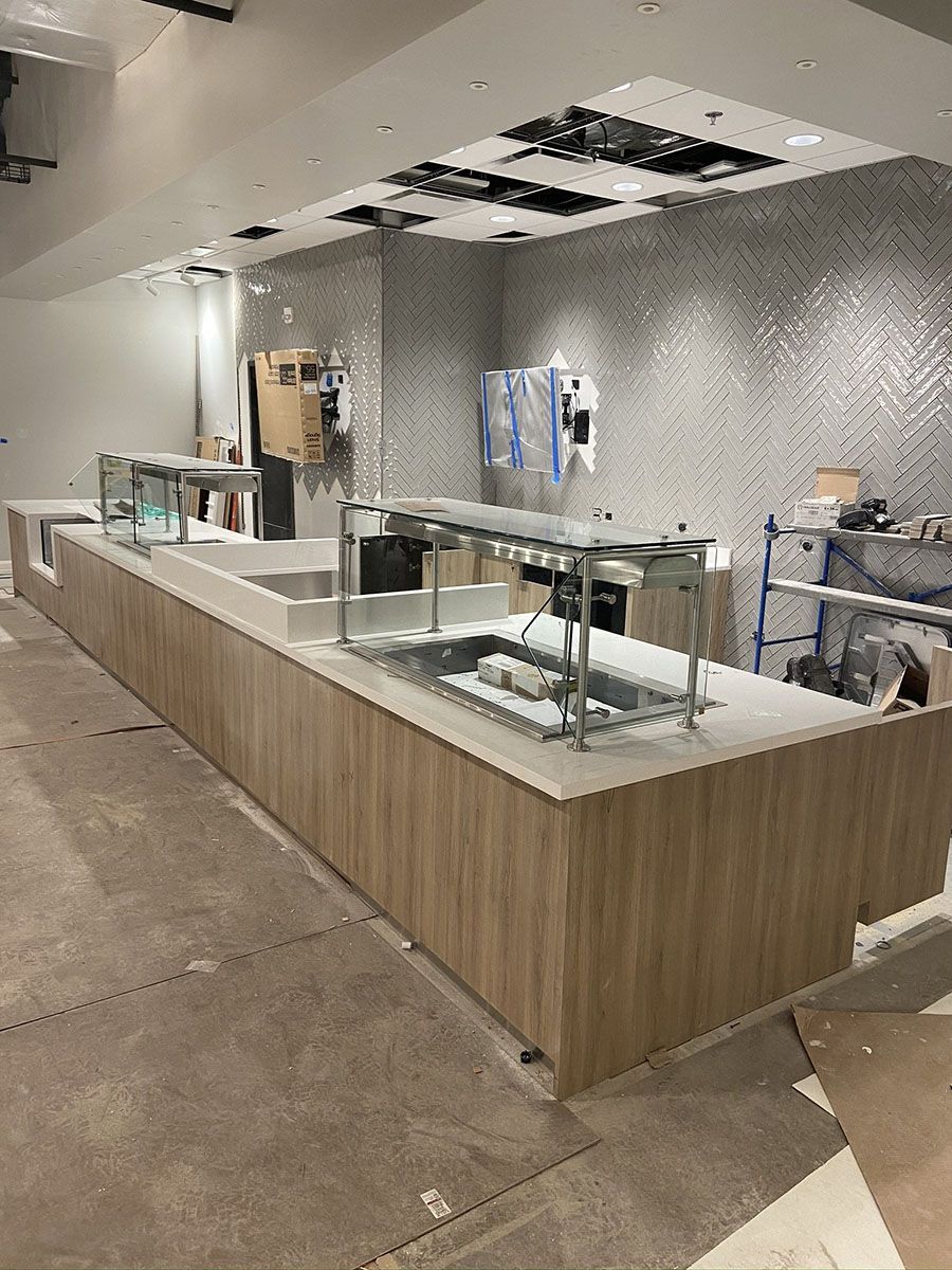 A long wooden counter in a restaurant under construction