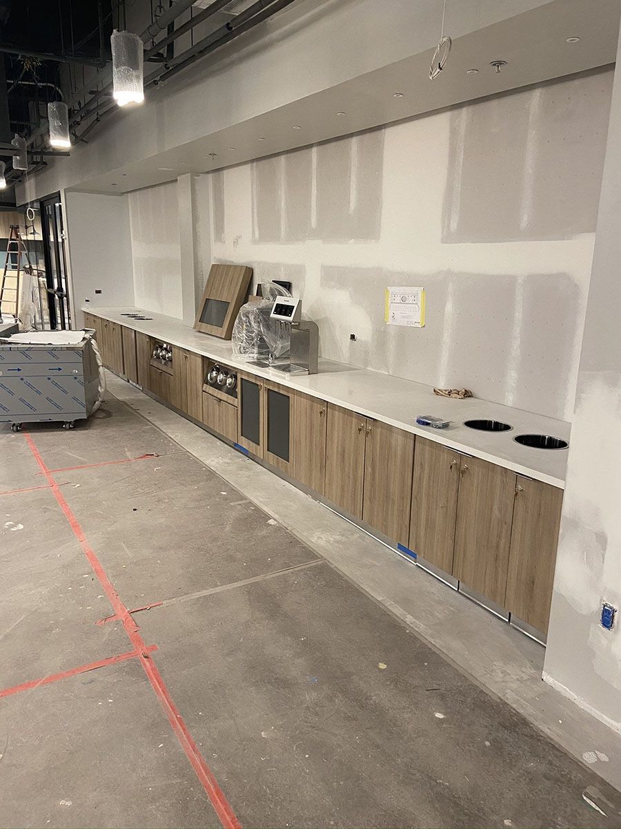 A kitchen under construction with wooden cabinets and white countertops