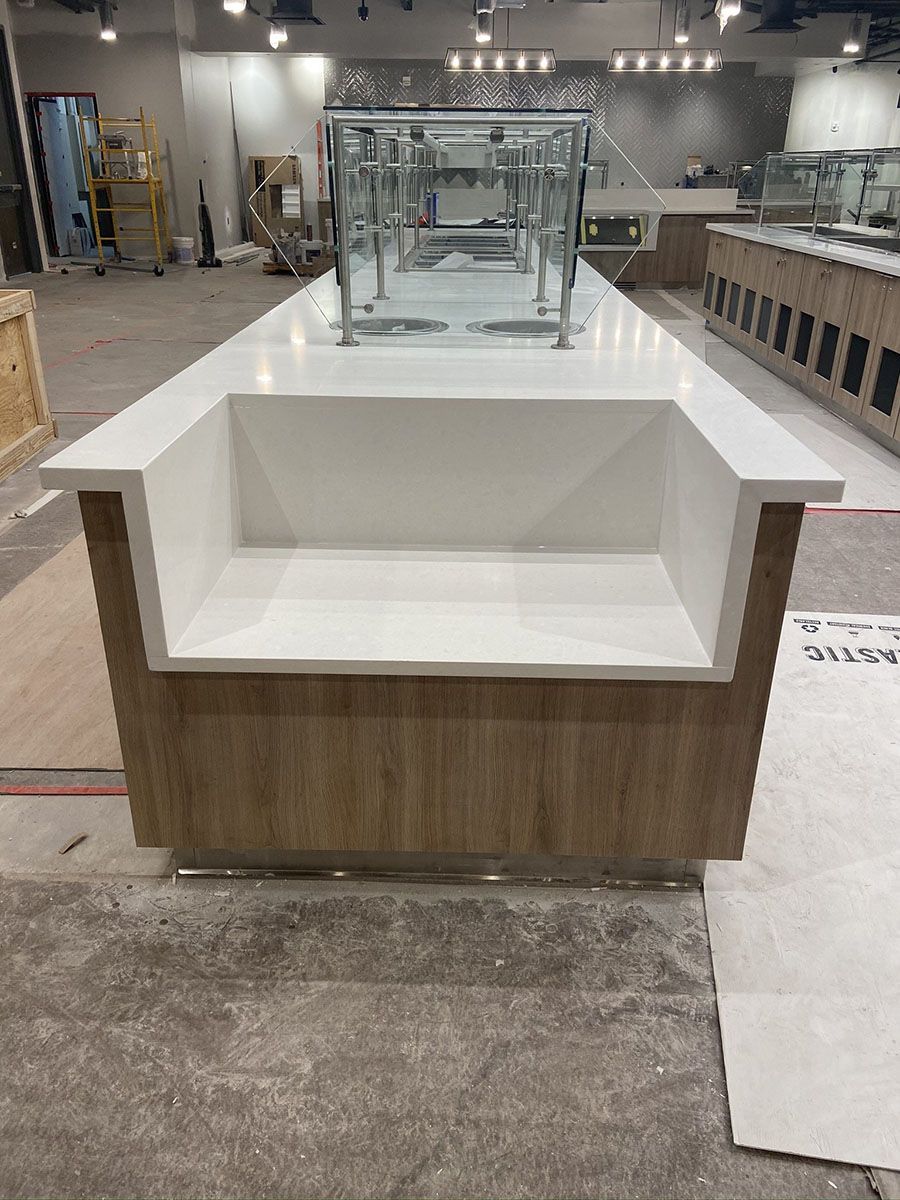 There is a large kitchen countertop in the middle of the room