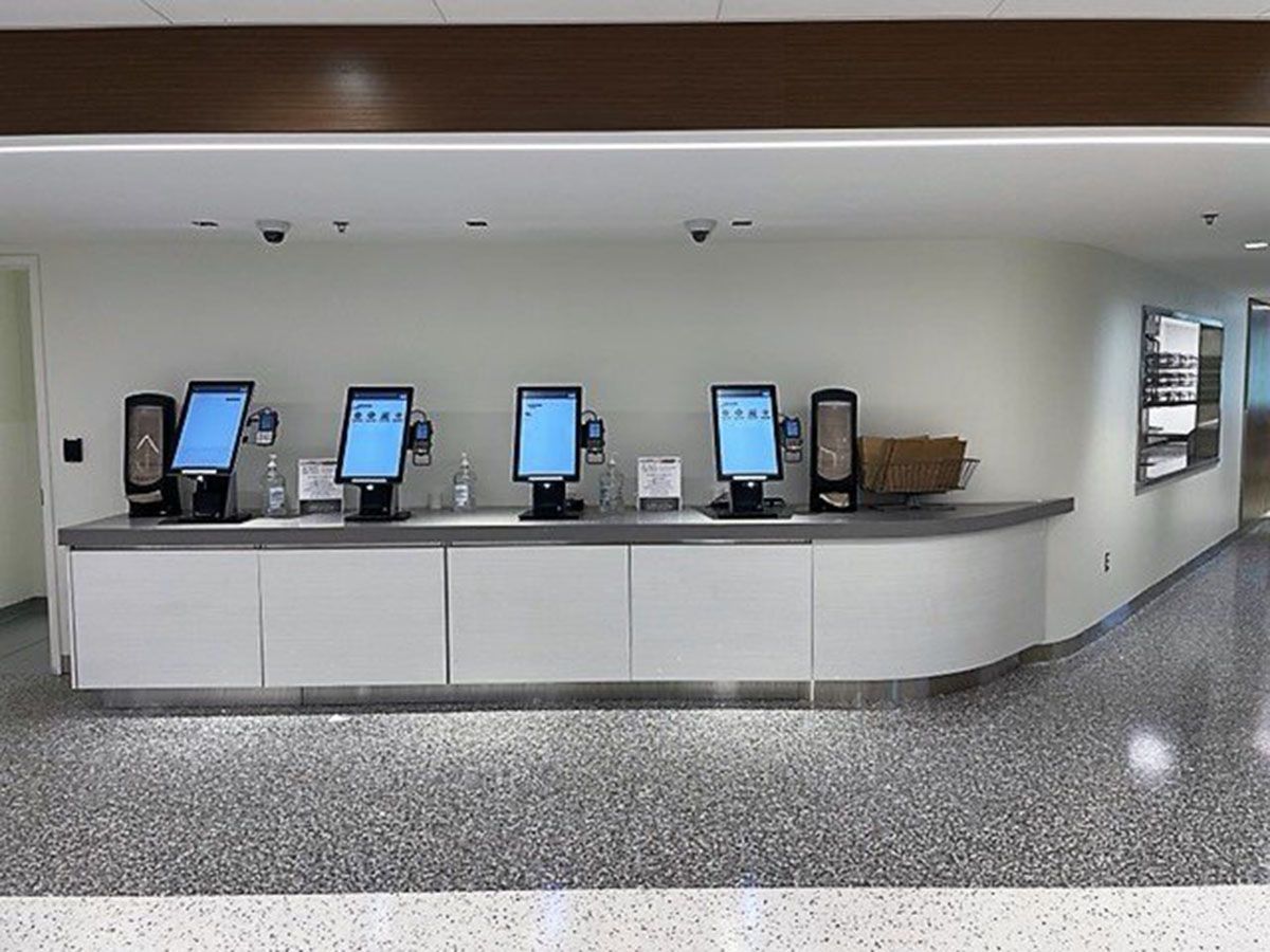A row of computer monitors sitting on top of a counter in a room