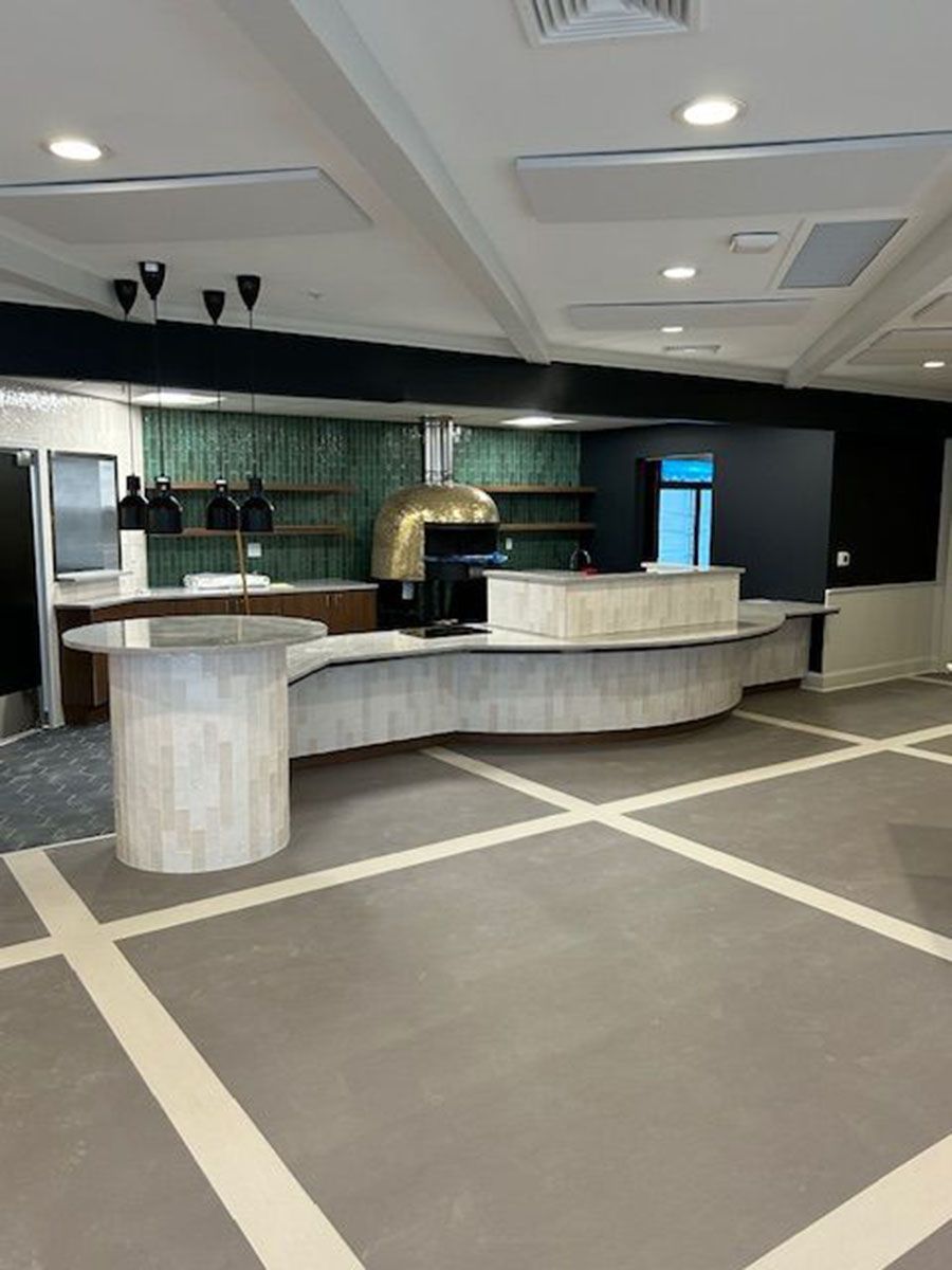 A large room with a counter and a pizza oven