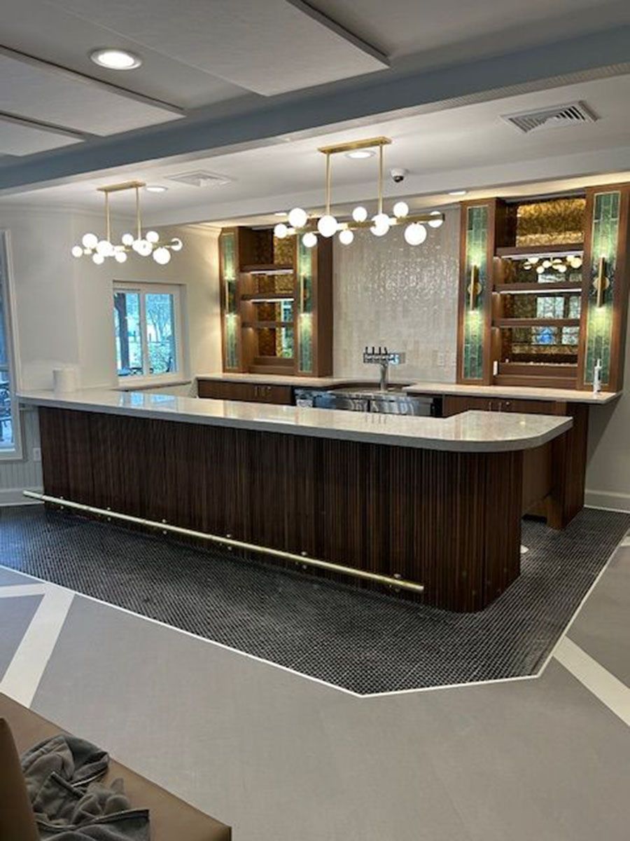 There is a long wooden bar in the middle of the room