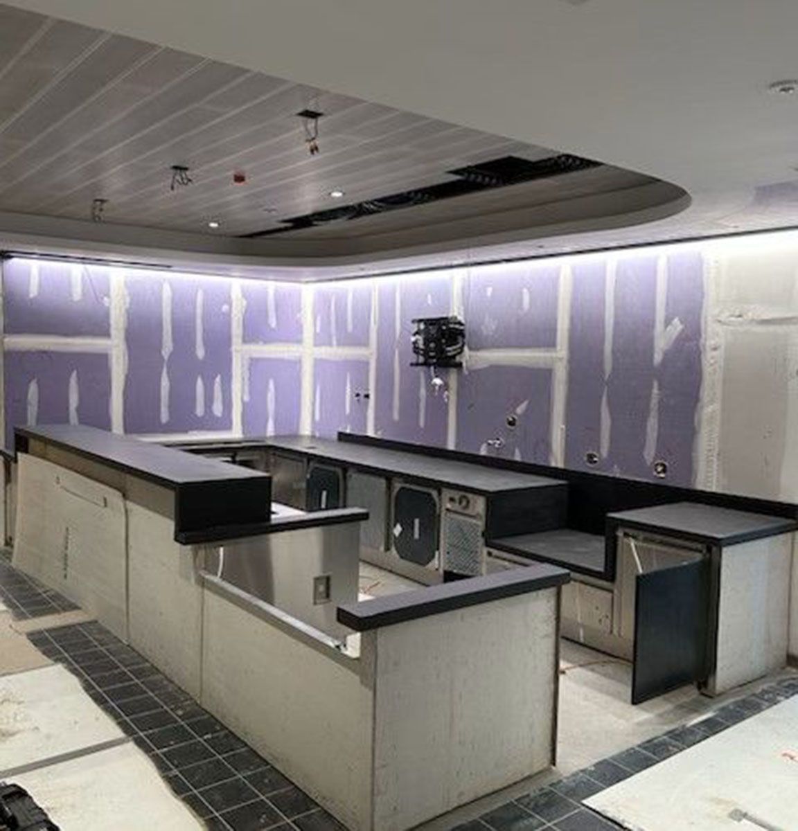 A kitchen under construction with black countertops