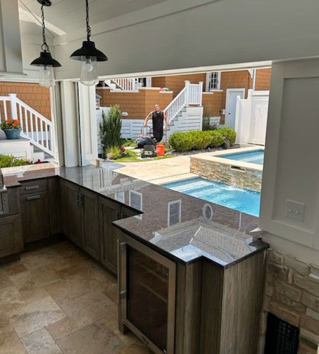A kitchen with a view of a pool and stairs