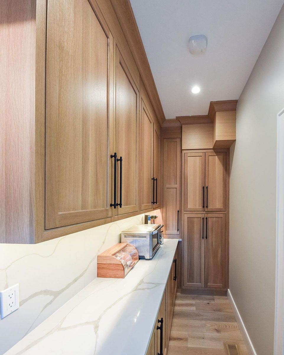 A kitchen with wooden cabinets and a microwave on the counter