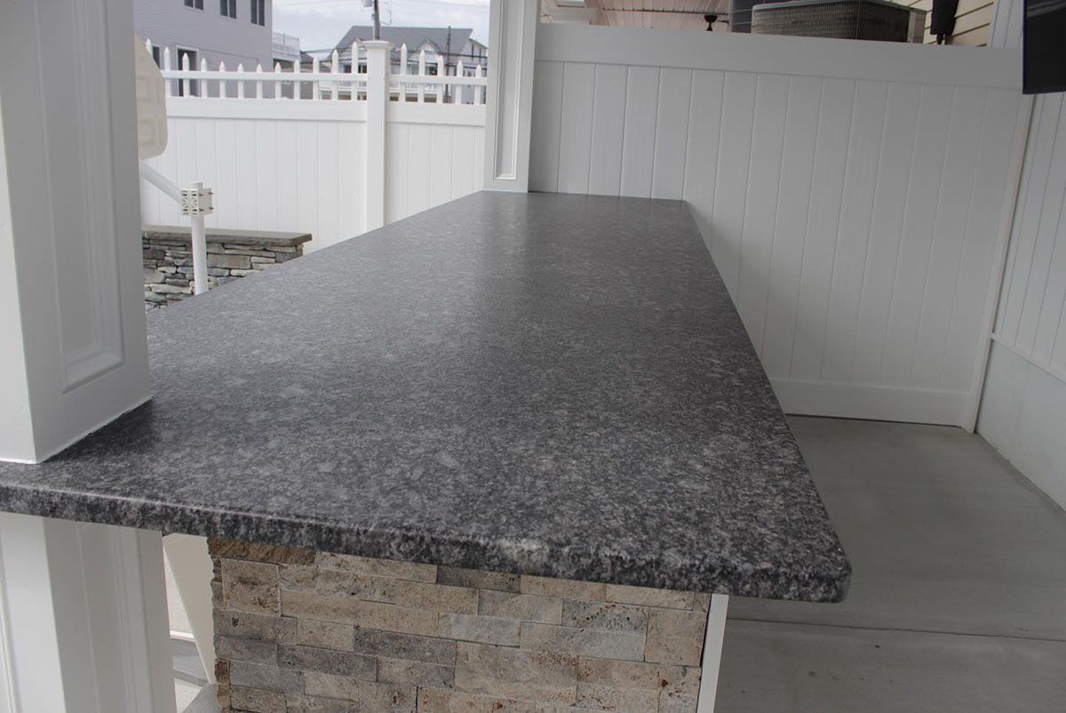 A kitchen with a granite countertop and white cabinets