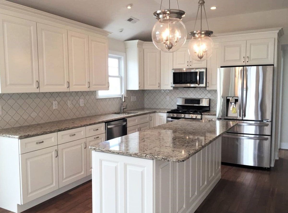 A kitchen with white cabinets and stainless steel appliances
