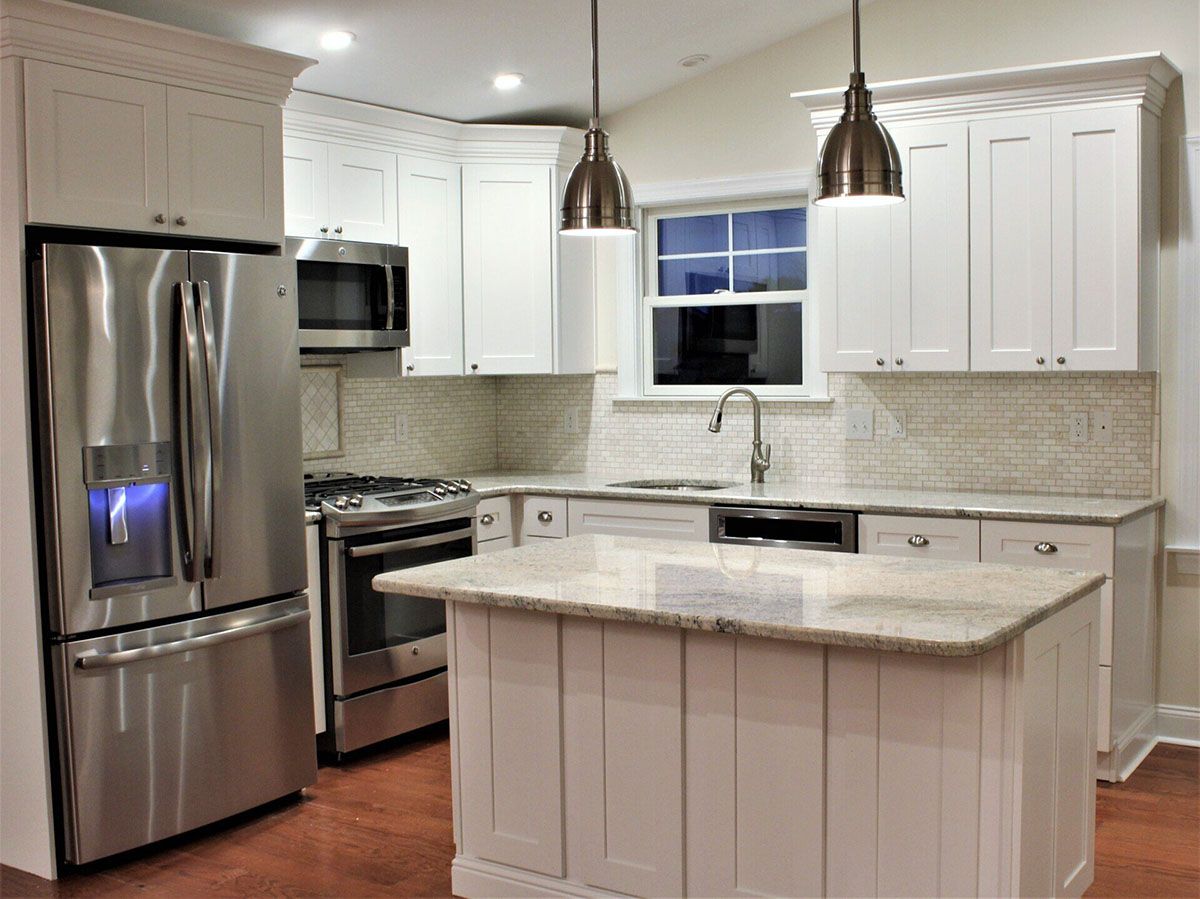 A kitchen with stainless steel appliances and white cabinets