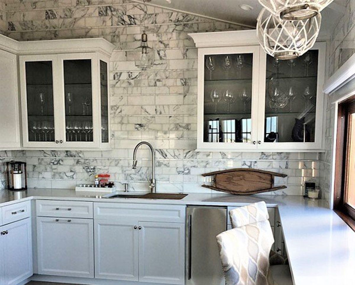 A kitchen with white cabinets and a sink