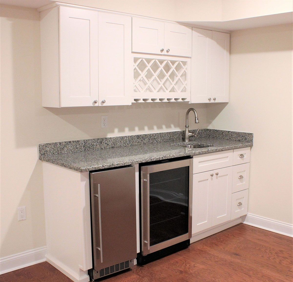 A kitchen with white cabinets and a stainless steel refrigerator