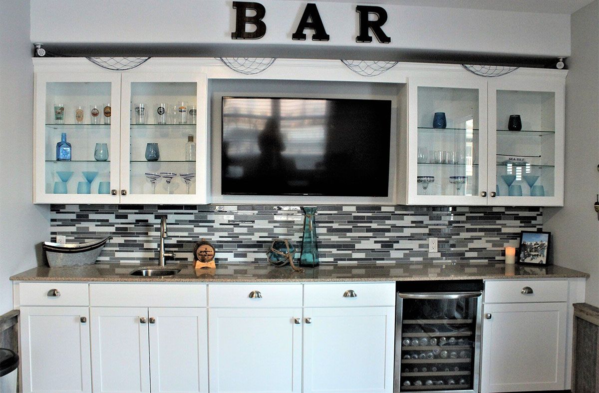 A kitchen with a bar and a flat-screen TV