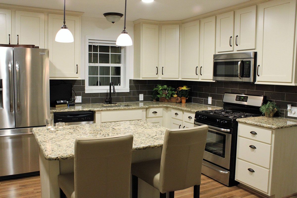 A kitchen with white cabinets and stainless steel appliances