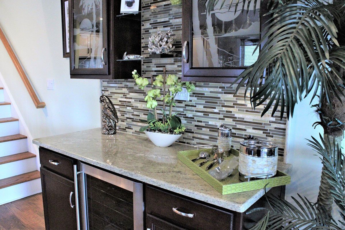 A kitchen with a staircase and a palm tree in the background