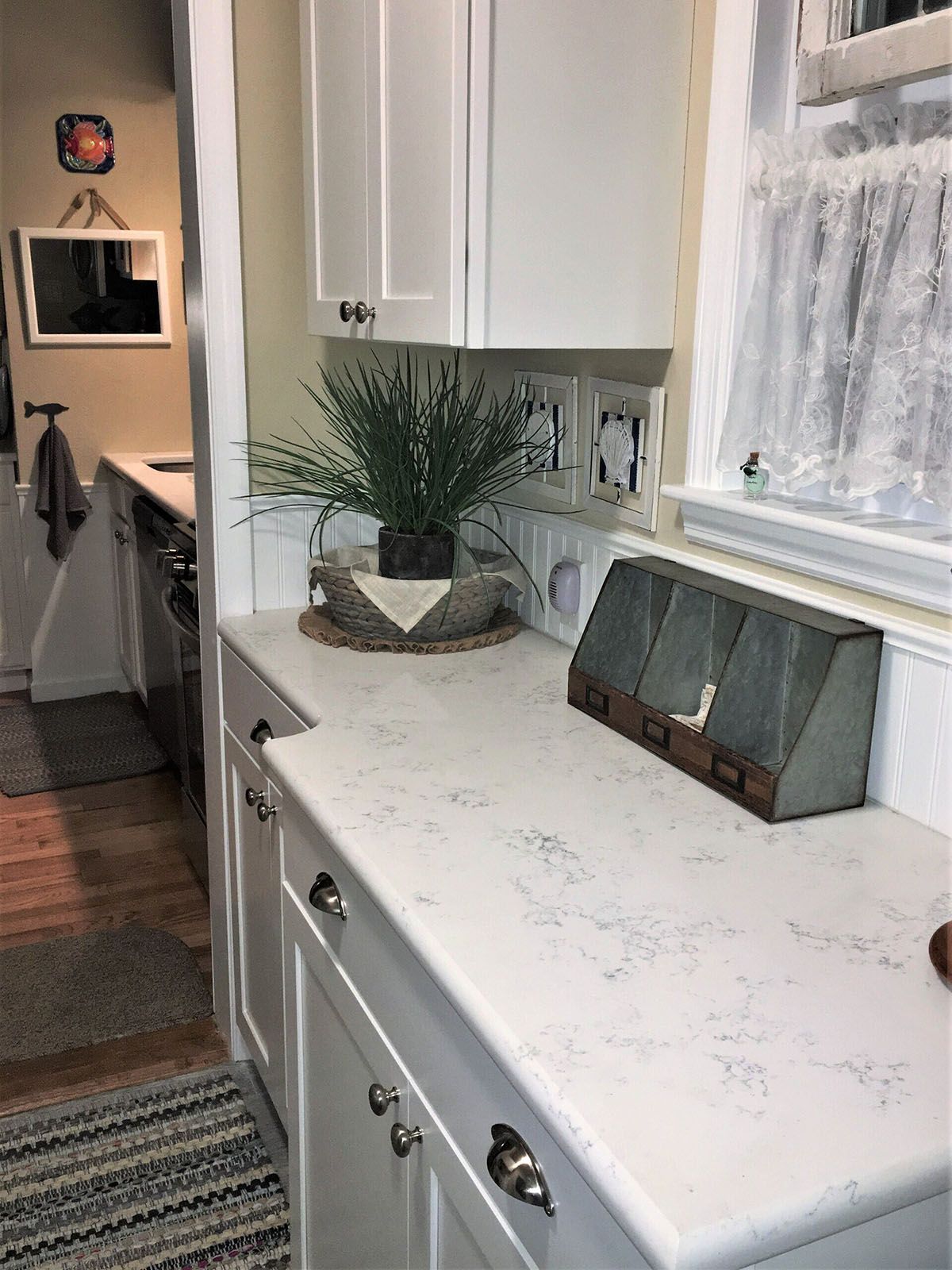 A kitchen with white cabinets and a white countertop