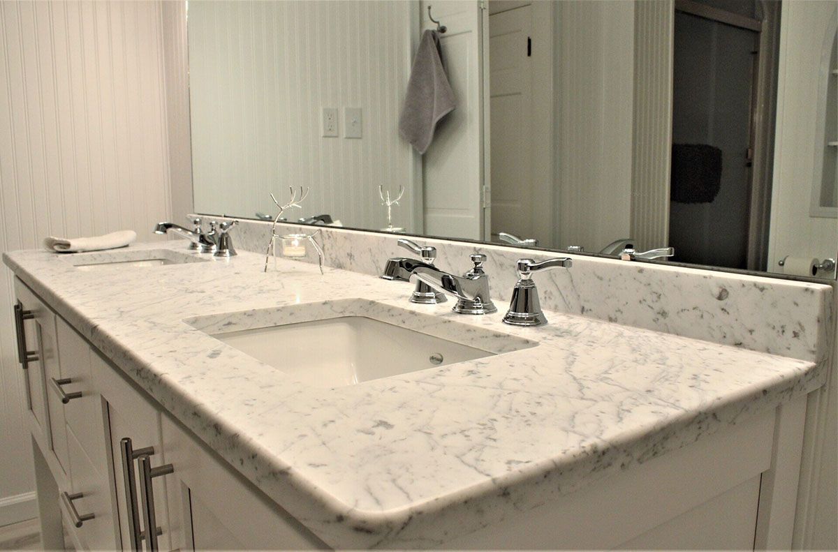 A bathroom with two sinks and a large mirror
