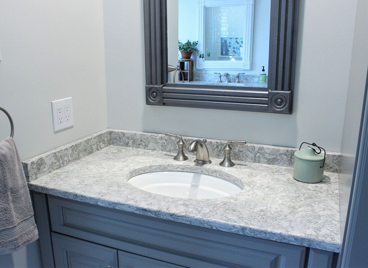 A bathroom with a sink, mirror, and towel rack