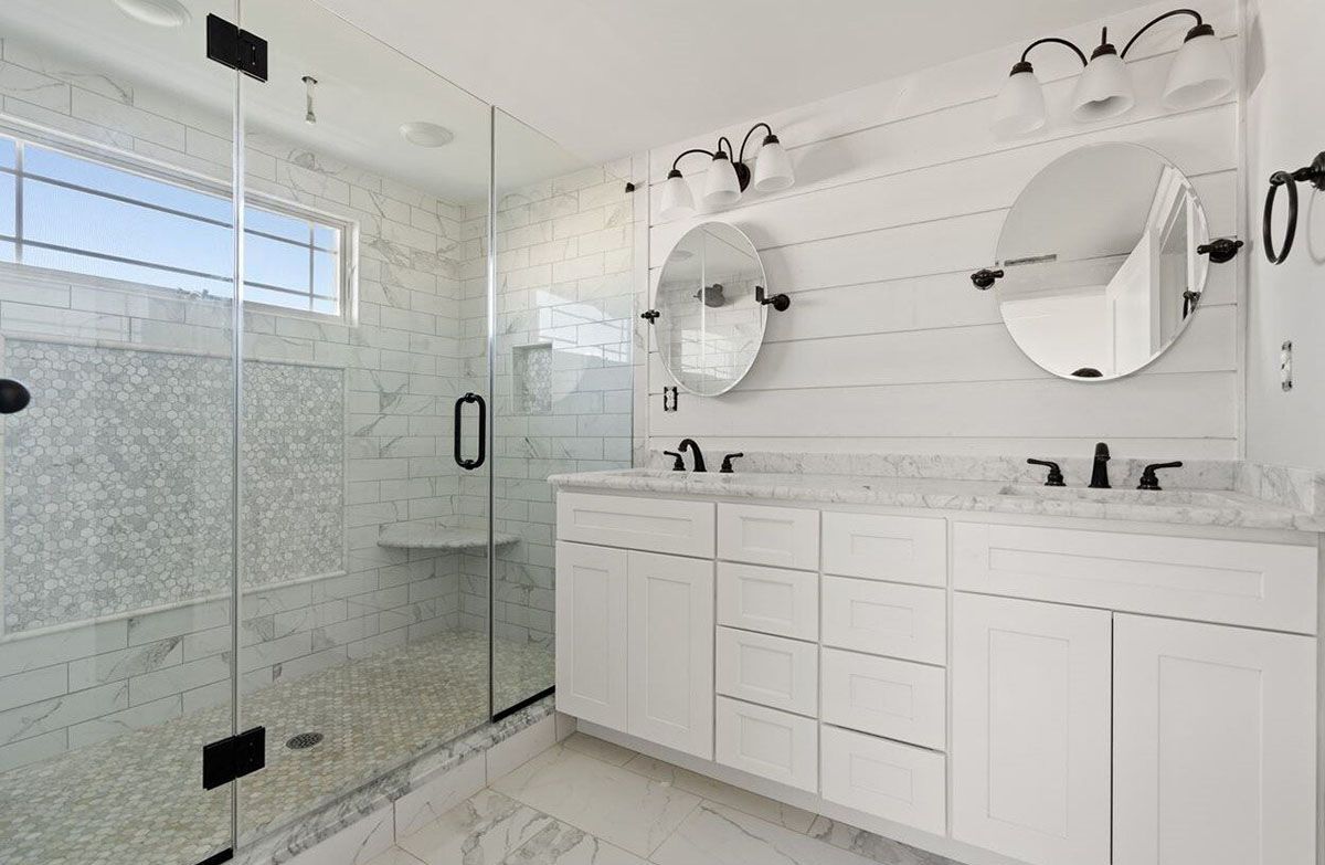 A bathroom with two sinks and a walk-in shower