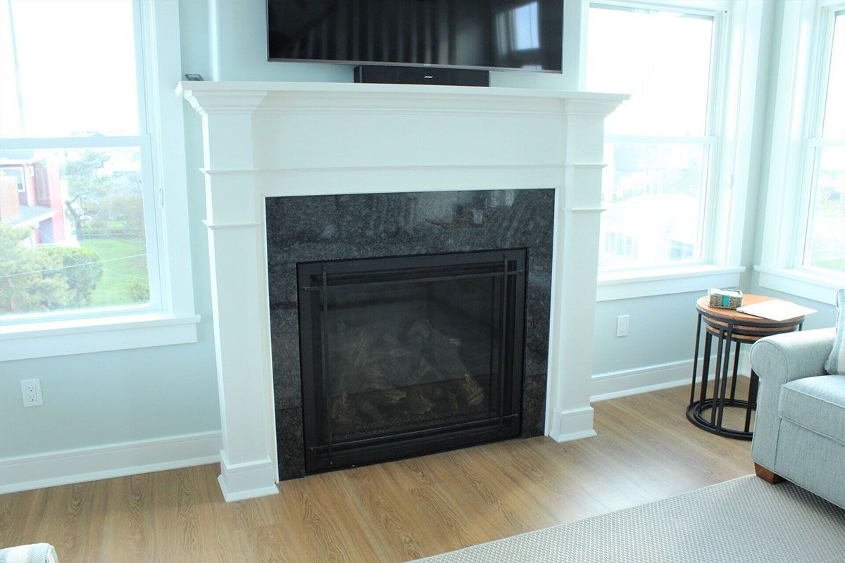 A living room with a fireplace and a flat-screen TV
