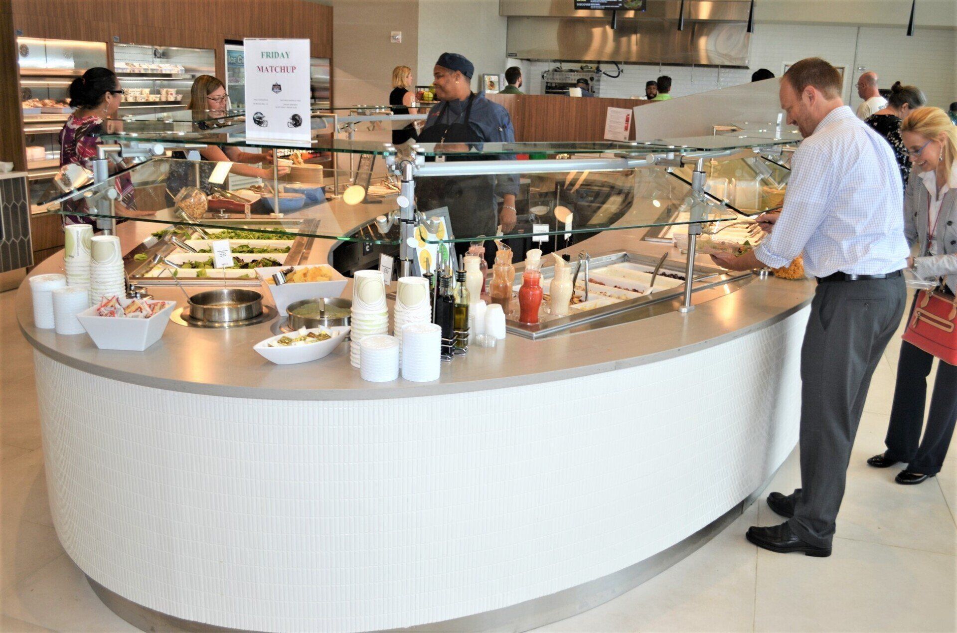 A man is standing in front of a buffet counter in a restaurant.