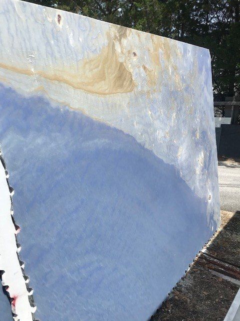 A large piece of blue marble is sitting on the ground