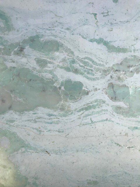 A close up of a green and white marble texture.
