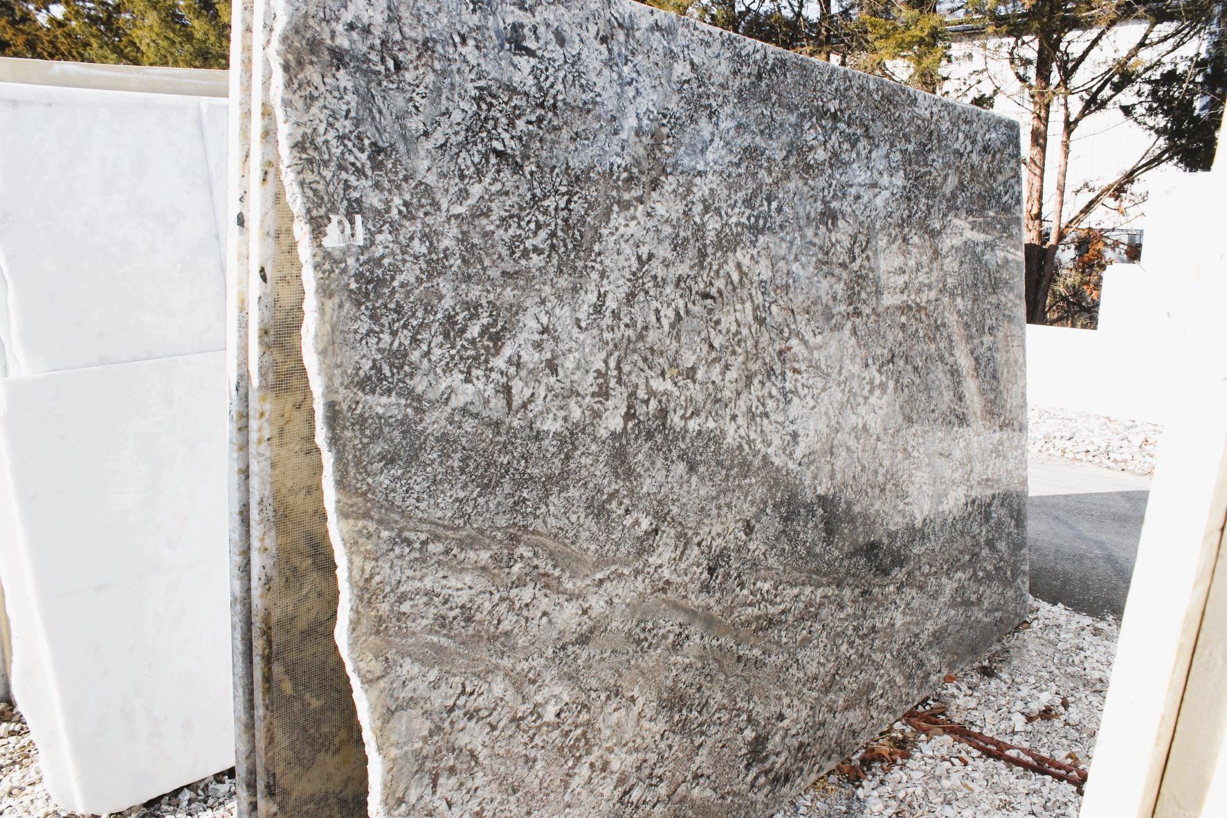A large piece of granite is sitting on top of a pile of smaller pieces of granite.