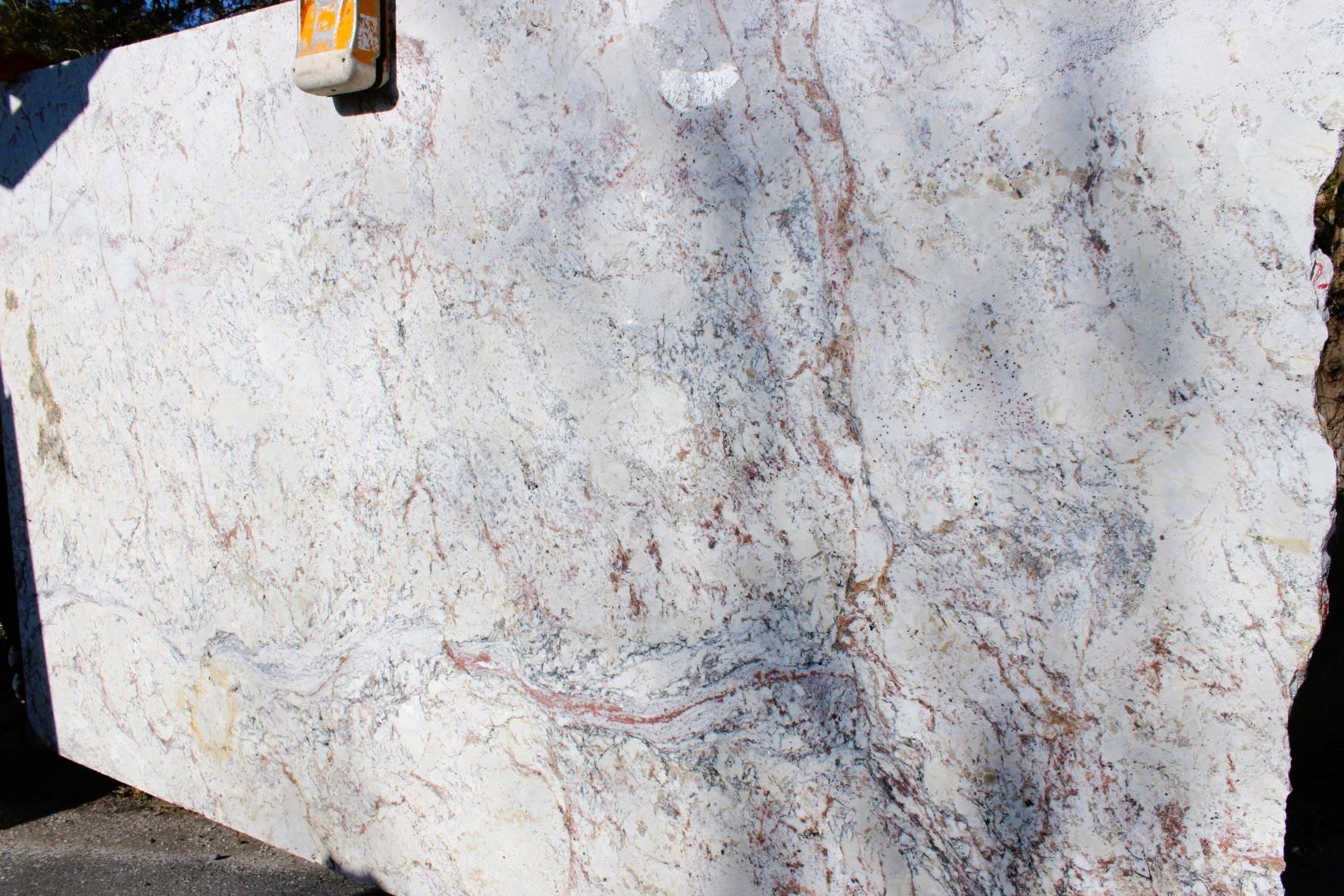 A large piece of white granite is sitting on the ground.