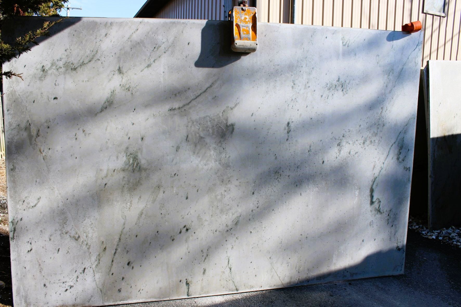A large piece of concrete is sitting in front of a building.