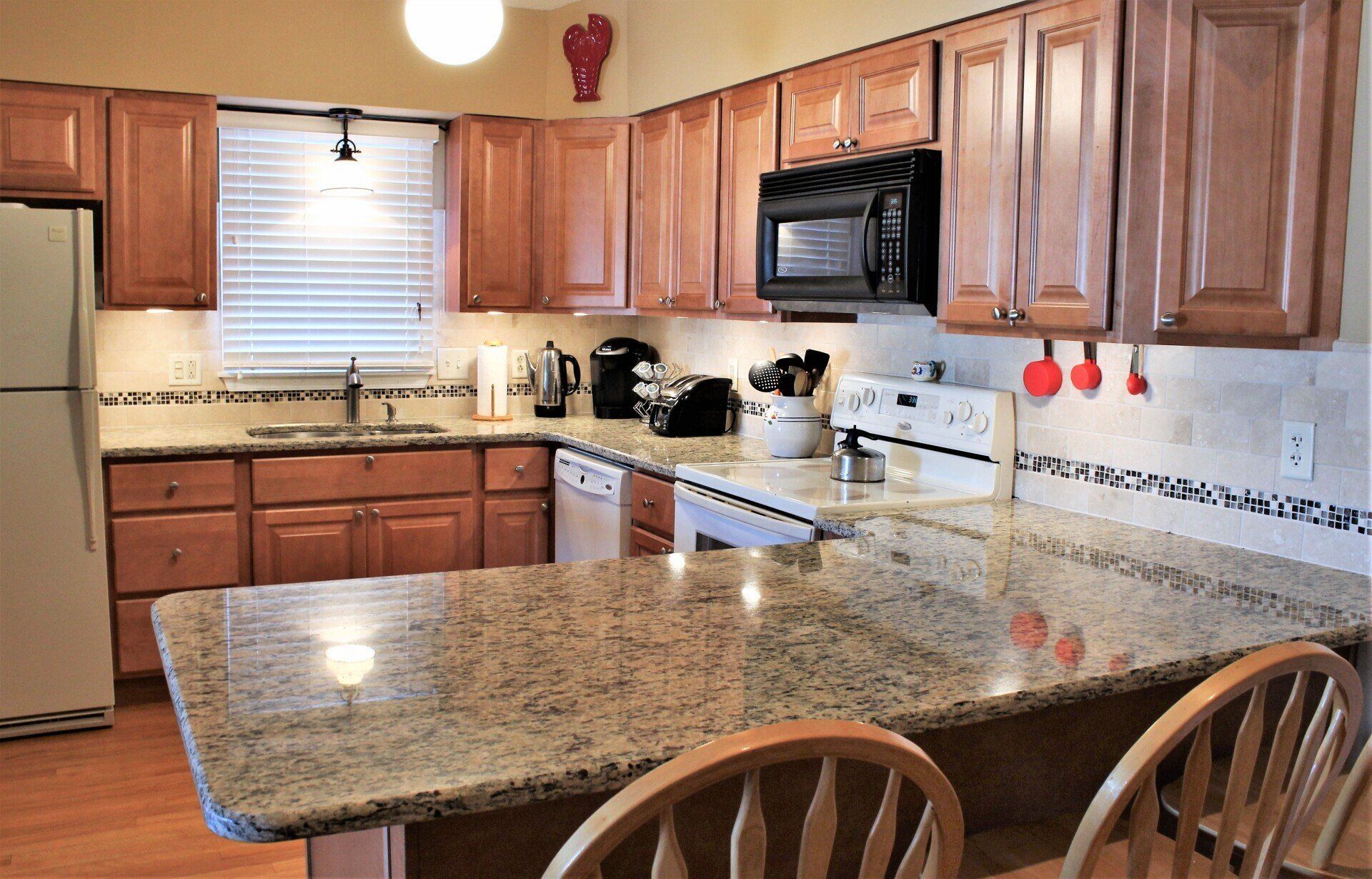 A kitchen with granite counter tops and wooden cabinets