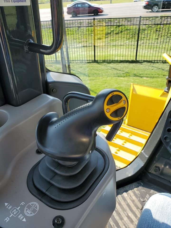 A person is sitting in the driver 's seat of a bulldozer.