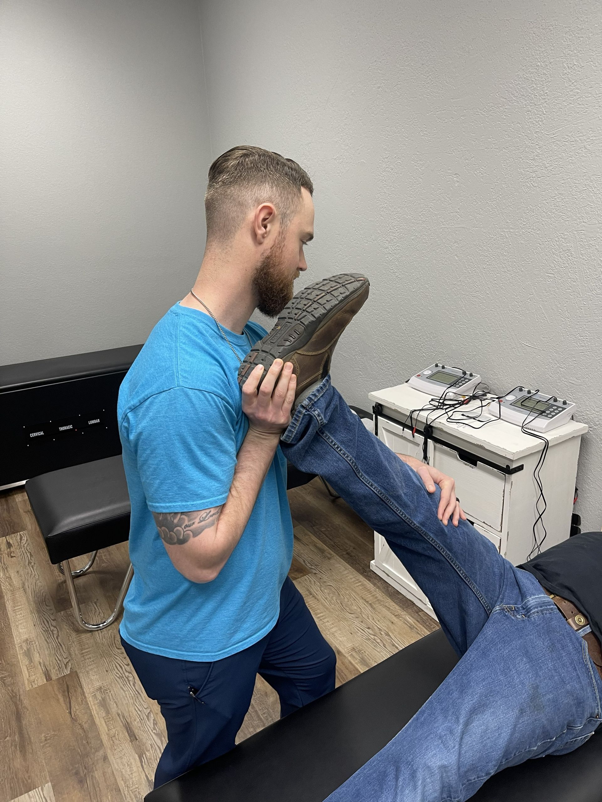 Physical therapist stretching a patient’s leg in a clinical room