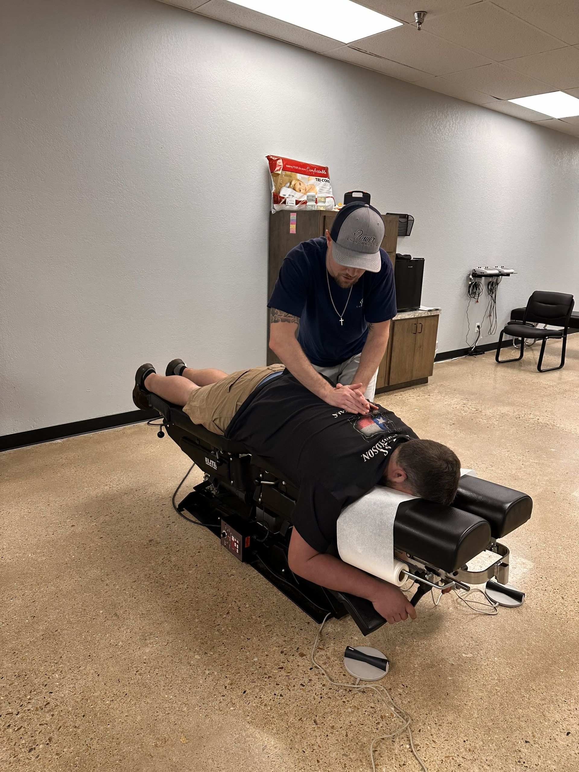 Therapist adjusting a patient on a treatment table in a clinical room