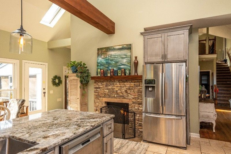 A kitchen with a stainless steel refrigerator and a fireplace.