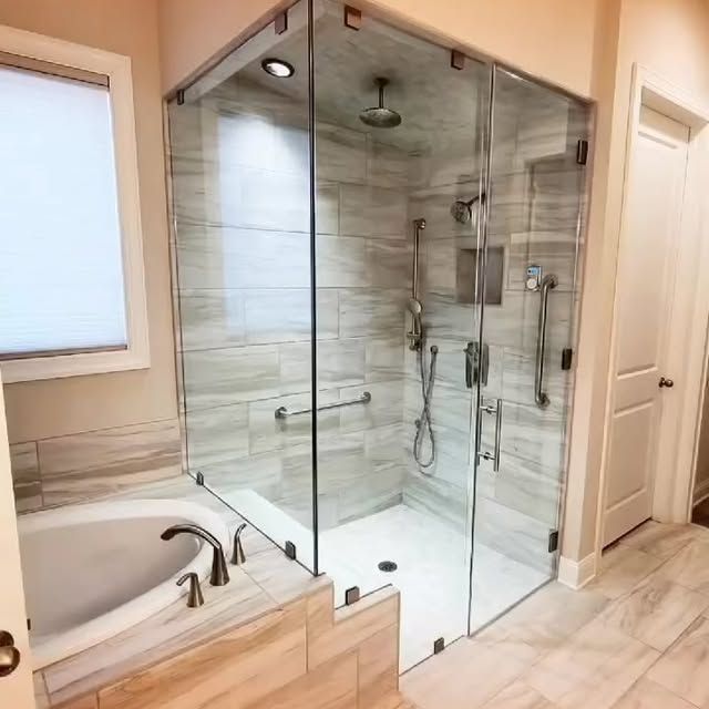 A bathroom with a tub and a walk in shower