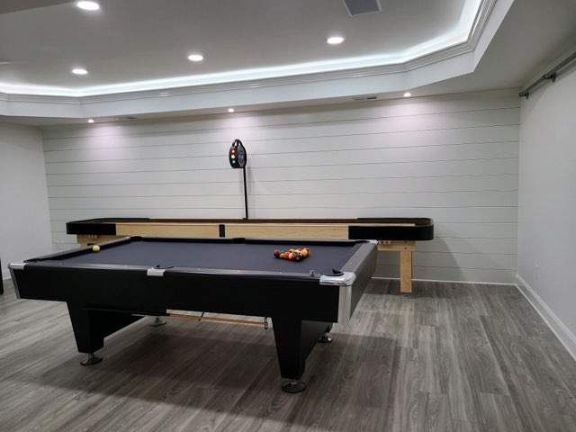 There is a pool table in the middle of the remodeled gaming room