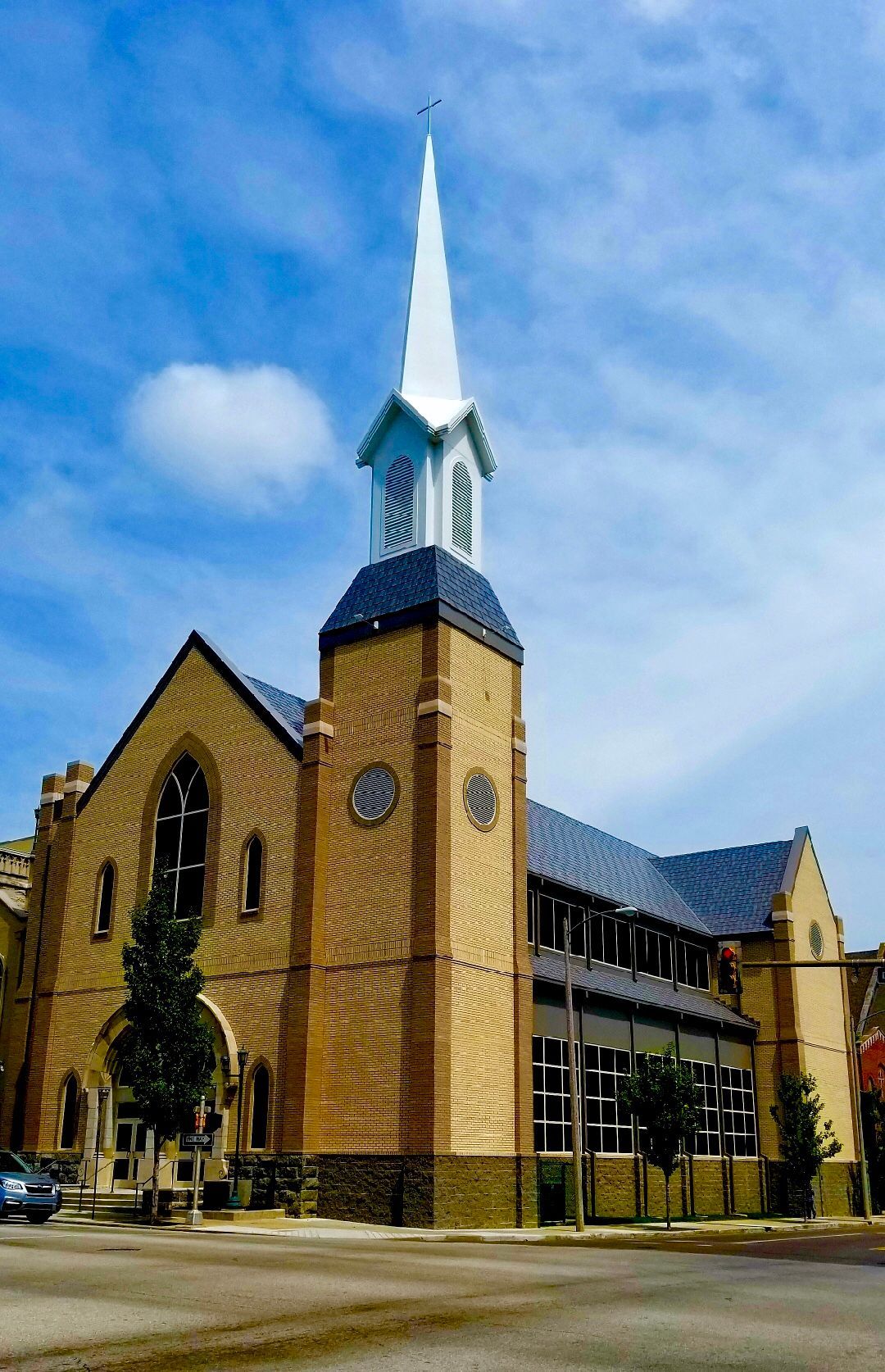 Brick church with steeple against a blue sky.